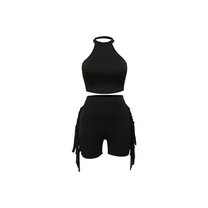 Close-up detail of black sleeveless halter neck crop top and matching fringe side shorts set