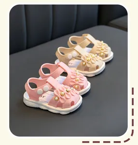 Detailansicht von rosa und beigen Kleinkindsandalen für Mädchen mit Perlenblumenakzenten.