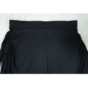 Detailed macro view of elegant black fringe tassels on a minimalist women's fashion set.