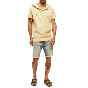 Vue d'un homme en sweat à capuche à manches courtes jaune pâle et short en jean délavé