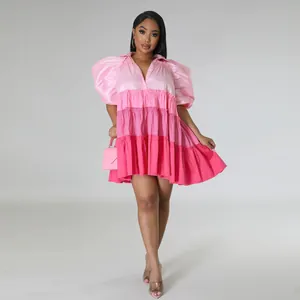 Detailed view of the tiered color-block pink satin dress featuring puff sleeves and V-neck