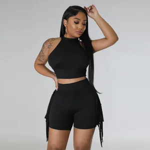 Detail view of the black sleeveless halter crop top and matching fringe side shorts set