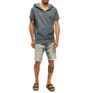 Vue de face d'un homme en sweat à capuche gris à manches courtes et short en jean sur blanc.