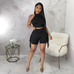 Stylish black two-piece set featuring a halter crop top and tassel biker shorts