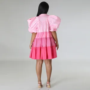 Back view of a pink tiered satin mini dress with dramatic puff sleeves and A-line hem