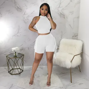 Full body shot of a white sleeveless halter top and fringe shorts two-piece set