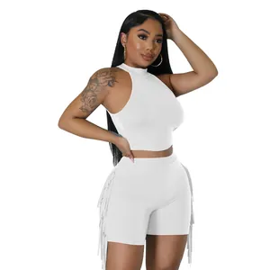 Close-up of white sleeveless mock neck crop top and fringe side shorts two-piece set