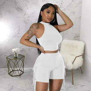 Full-length view of white sleeveless fringe two-piece set on a fashion model in a room
