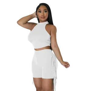 Detail view of white sleeveless halter crop top and fringe shorts two-piece set