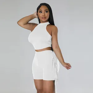 Chic white two-piece set featuring a sleeveless halter crop top and tassel fringe shorts