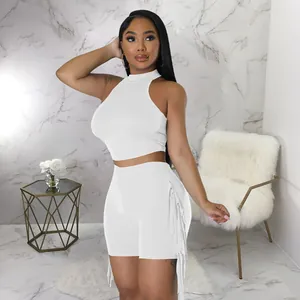 Close-up of white sleeveless high-neck crop top and fringe shorts two-piece set