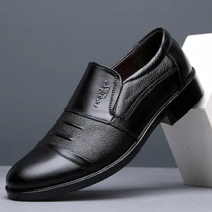 Detail view of black genuine leather loafers with textured panel and embossed logo