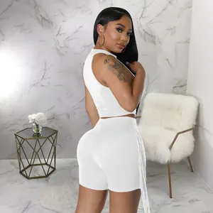 Side view of white sleeveless crop top and shorts set with fringe details