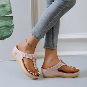 Vue détaillée des sandales à talons compensés roses avec découpes et boucle en métal