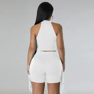 Back view of white sleeveless crop top and shorts set with stylish side fringe details.