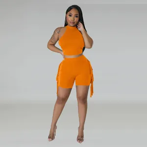 Macro view of the vibrant orange two-piece set with stylish tassel fringe shorts