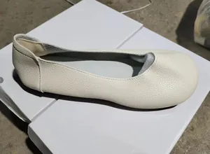Vista dettagliata di scarpe basse bianche a punta tonda con finitura in pelle