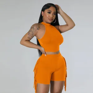 Detail view of orange sleeveless two-piece set featuring stylish side fringe trim