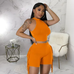 Vibrant orange two-piece women's outfit with sleeveless crop top and side fringe shorts.