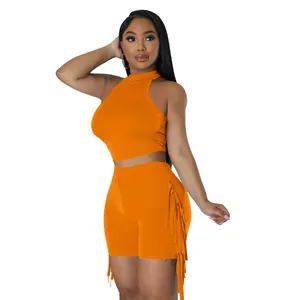 Bright orange sleeveless halter top and high-waisted shorts set with stylish side fringe details