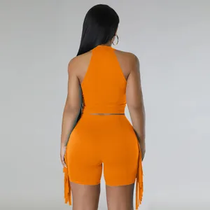 Back view of vibrant orange sleeveless halter crop top and fringe shorts two-piece set