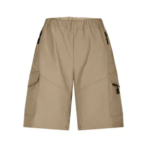 Detailed view of men's khaki cargo shorts featuring functional multi-zippered pockets