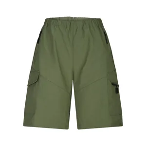 Front view of durable men's cargo shorts in olive green featuring functional multi-zipper pockets.