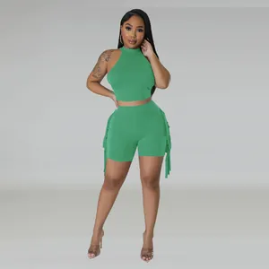 Women's chic green two-piece set featuring sleeveless halter top and fringe shorts.