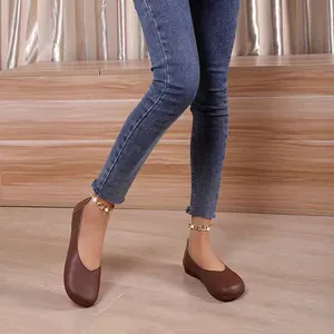 Eleganti ballerine in pelle marrone a punta tonda abbinate a jeans e cavigliere dorate