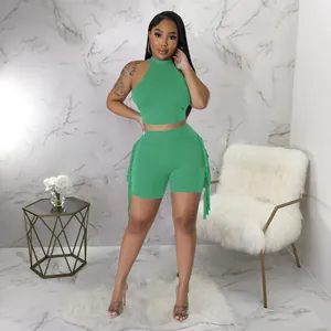 Chic two-piece set with green sleeveless crop top and matching fringe shorts for summer.