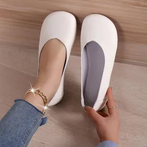 Dettaglio di scarpe basse bianco crema a punta tonda con trama in pelle