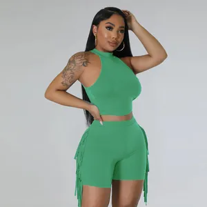 Detailed view of women's green sleeveless crop top and matching shorts with side fringe detail