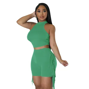 Women's two-piece set featuring green sleeveless halter top and fringe trim shorts