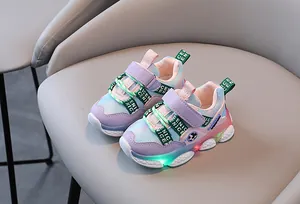 Λεπτομέρεια από παιδικά LED sneakers με μωβ πλέγμα που αναπνέει και φωτεινές σόλες.