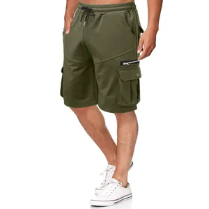 Close-up detail of men's olive green cotton cargo shorts featuring functional multiple pockets