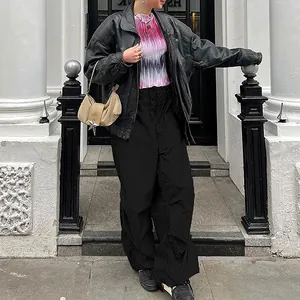 Street style view of loose fit black wide-leg cargo pants for women with drawstring detail