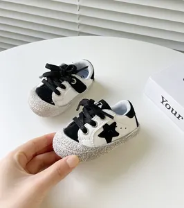 Detailansicht von Baby-Lauflernschuhen mit schwarzem Sternmuster und rutschfester weicher Sohle