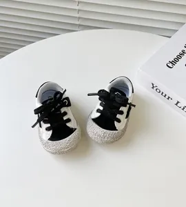 Nahaufnahme von schwarz-weißen Lauflernschuhen für Kleinkinder mit dicker Gummisohle