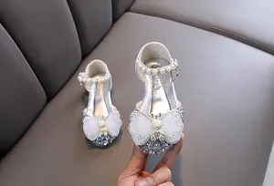 Nahaufnahme silberner Glitzer-Prinzessinnenschuhe für Mädchen mit Schmetterlingsdetails.