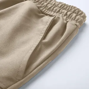 Close-up of elastic waistband and pocket detail on khaki cotton cargo shorts