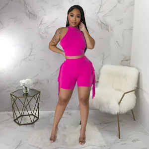 Fashion model in hot pink sleeveless halter top and tassel shorts two-piece set detail