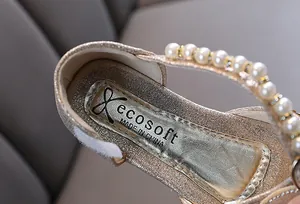 Detailaufnahme goldene Glitzer-Prinzessinnenschuhe für Mädchen mit Perlenriemen.