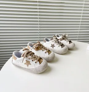 Detailansicht stilvoller weiß-brauner Lauflernschuhe mit Stern-Patch und weicher Gummisohle