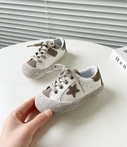 Detailansicht weißer Lauflernschuhe für Jungen mit braunem Stern und strukturierter Sohle