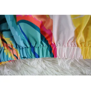 Vista detallada del colorido estampado abstracto y el dobladillo elástico fruncido del vestido.