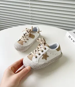 Detailansicht von weißen Baby-Sneakern mit Stern-Patch und strukturierter Sohle