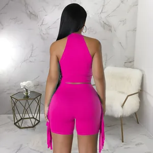 Back view of hot pink two-piece set featuring sleeveless halter top and trendy fringe shorts