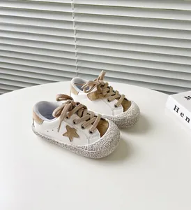 Detailansicht weißer und brauner Kleinkindschuhe mit Sternmuster-Details