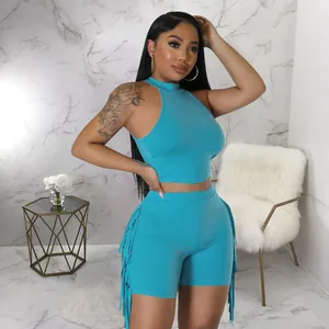 Detail of vibrant cyan two-piece set featuring fringe trim and sleeveless mock neck top