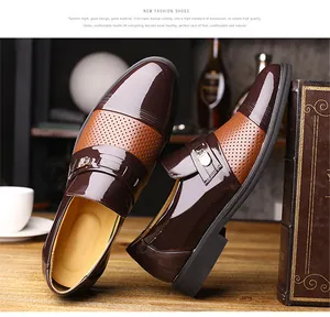 Close-up view of brown hollowed-out men's business formal shoes with metal buckle